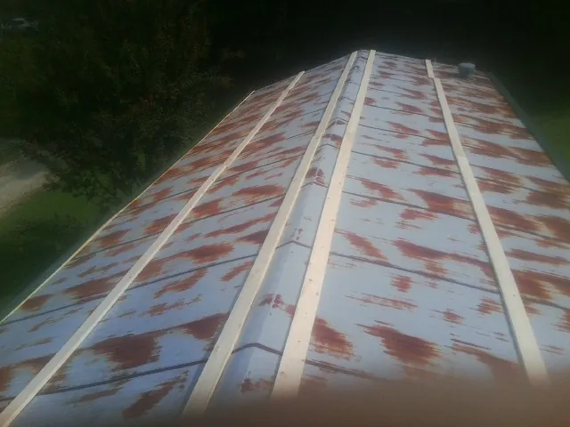 Rusted metal roof panels with new wood purlins before replacement — Storm Damage Roof Repair in Greenbackville by Roofing Brothers